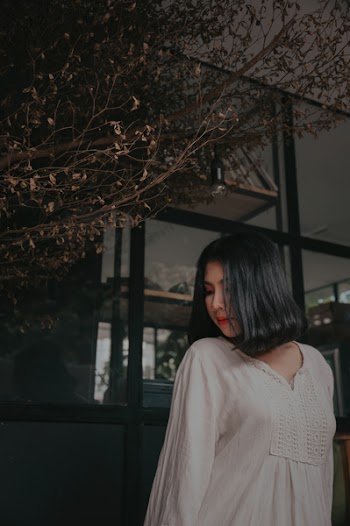 Woman Wearing White V-neck Long-sleeved Shirt Standing Beside Brown Tree