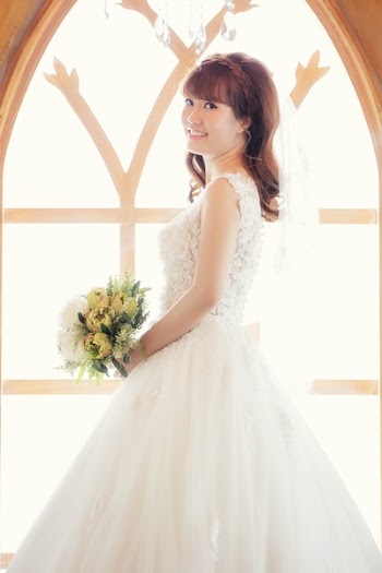 Woman Wearing White Wedding Gown Holding Bouquet of Yellow Flowers