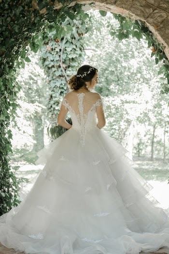 Woman Wearing White Wedding Gown Standing While Facing Back on Garden