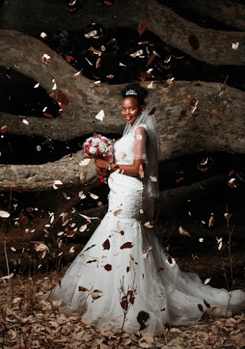 Woman Wearing White Wedding Gown While Holding Bouquet of Flower Near Tree