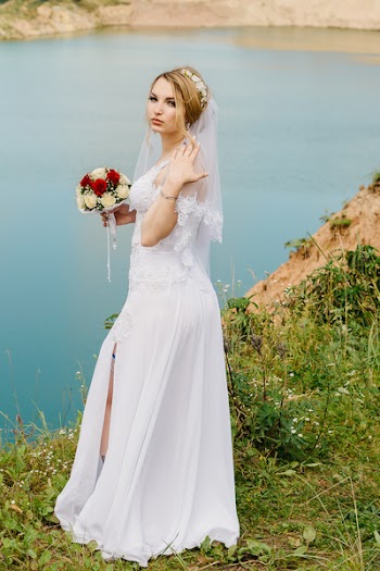 Woman Wearing White Wedding Gown While Standing on Cliff Near River
