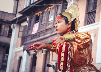 Woman Wearing Yellow And Red Traditional Dress Dancing Near Building