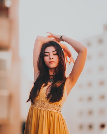 Woman Wearing Yellow Floral V-neck Sleeveless Dress Raising Her Arms Above Her Head