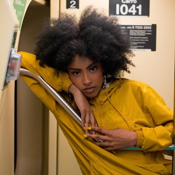 Woman Wearing Yellow Jacket Leaning on Metal Bar