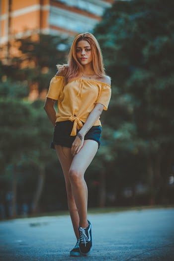 Woman Wearing Yellow Off-shoulder Blouse Standing on Road