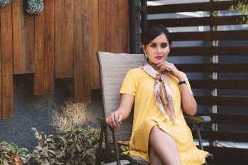 Woman Wearing Yellow Short-sleeved dress Sitting on Black Metal Armchair