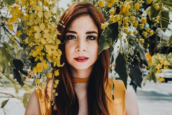 Woman Wearing Yellow Sleeveless Top Standing Near Flowers
