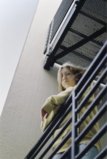 Woman Wearing Yellow Sweater Leaning on Railing