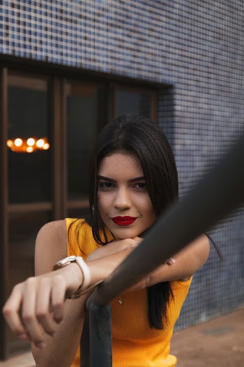 Woman Wearing Yellow Tank Top Leaning on Railing