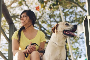 Woman Wearing Yellow V-neck T-shirt Beside Short-coated White and Brown Dog at Daytime