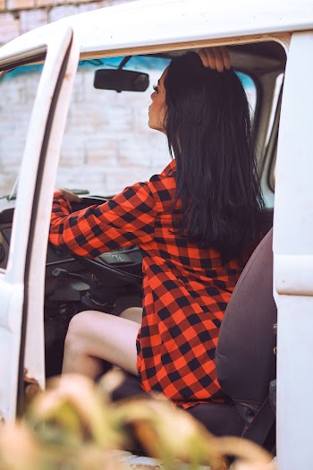 Woman Wears Black and Red Checked Sport Shirt Fixing Her Hair Inside Vehicle