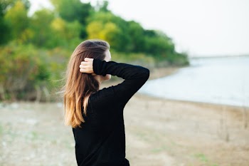 Woman Wears Black Long-sleeved Shirt Standing Near Body of Water