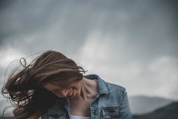 Woman Wears Blue Denim Top and White Inner Smiling