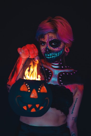 Woman With A Face And Body Painting Holding A Halloween Pumpkin Bucket