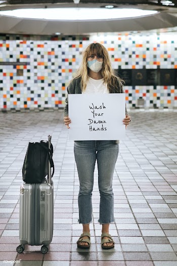 Woman with a suitcase holding wash your damn hands sign during the cor.. | Free  psd mockup - 2330311