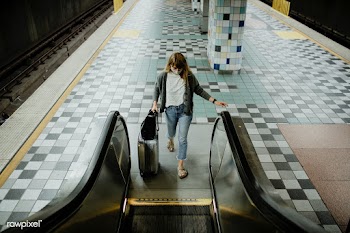 Woman with a suitcase on an escalator during the coronavirus pandemic  | Free  photo - 2327678