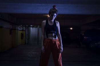 Woman With Black Sports Bra and Red Pants in Dark Room