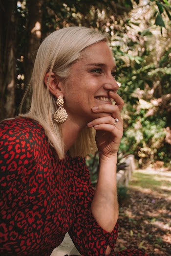 Woman with Blond Hair Smiling While Holding Her Chin