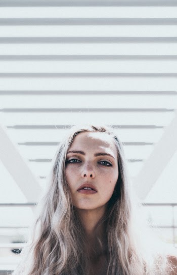 Woman with Blonde Hair Beside White Wall