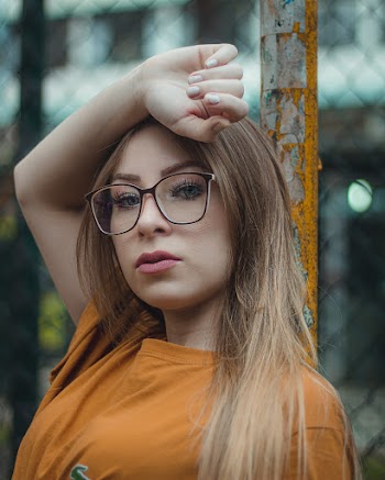 Woman With Blonde Hair Leaning On Pole