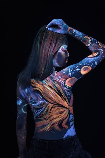 woman with body tattoo standing in the dark