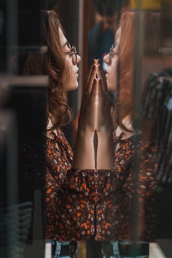 Woman With Both Hand on Glass Wall