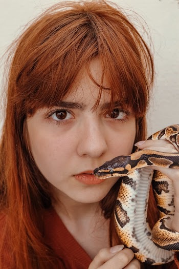 Woman With Brown Hair Holding a Snake