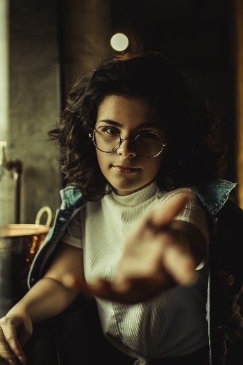 Woman With Curly Hair And Eyeglasses Extending Her Arms