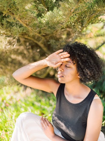 Woman with Curly Hair Covering Her Face With Hand