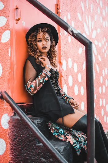 Woman With Curly Hair Sitting Down on Steps