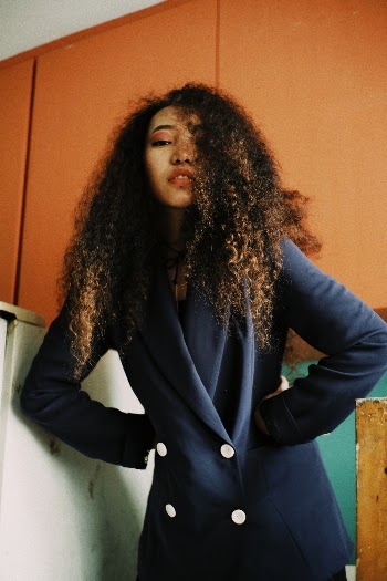 Woman With Curly Hair Wearing Blue Blazer
