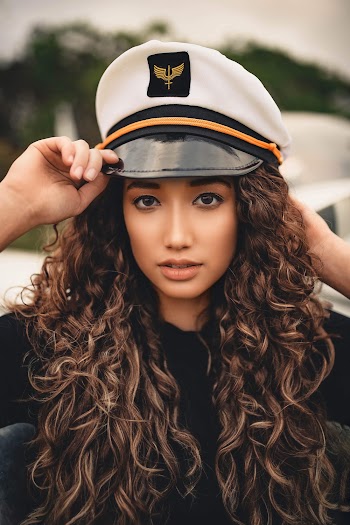 Woman With Curly Hair Wearing White Peaked Cap
