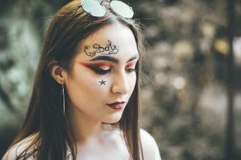 woman with face paint wearing sunglasse s