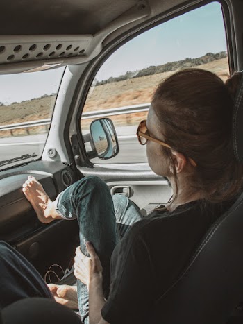 Woman With Foot Up Inside A Vehicle