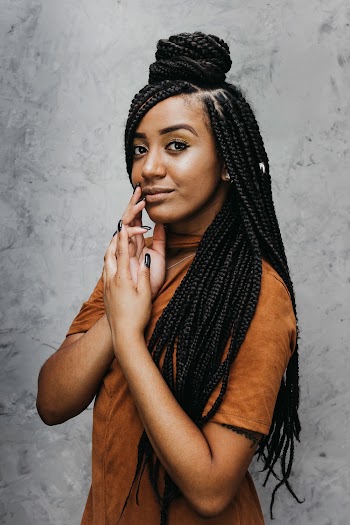 Woman With Long Dreadlocks Smiling and Touching Her Cheek