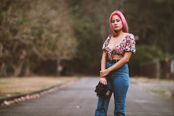 Woman With Pink Hair and Holding Camera Standing at the Street