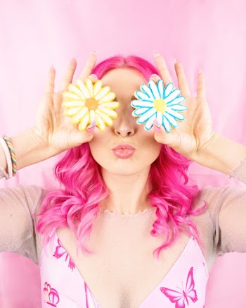 Woman with Pink Hair holding Flower Cookies