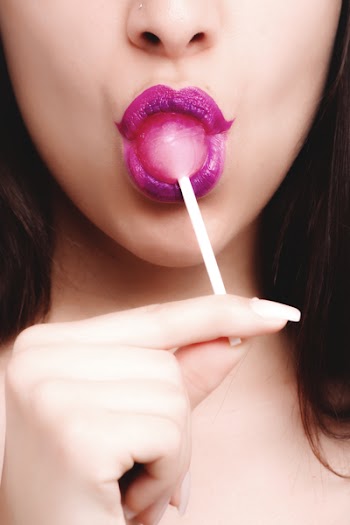 Woman With Pink Lipstick Licking Strawberry Lollipop