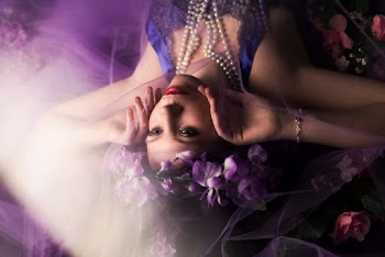 Woman With Purple Flower Headress Holding Cheeks