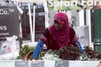 Woman With Purple Hijab Standing in Front of Vegetables