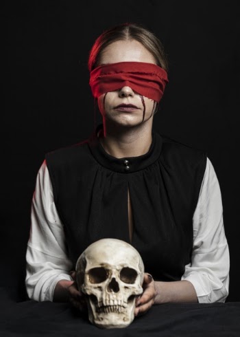 Woman with red blindfold holding skull Free Photo