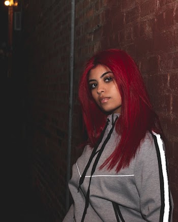 Woman With Red Hair Wearing A Black and White Zip-up Jacket