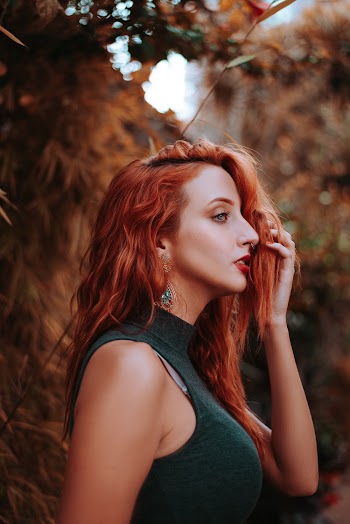 Woman With Red Hair Wearing Black Turtle-neck Sleeveless Top on Sideways