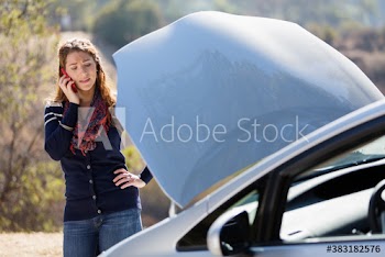 Woman with smart phone calling for help with vehicle breakdown