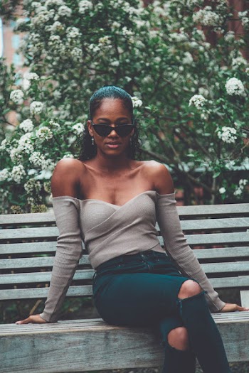 Woman With Sunglasses Sitting on Bench Near Flowers