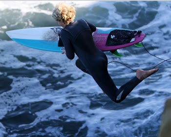 Woman With Surfboard Jumping to Body of Water