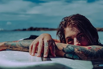 Woman With Tattoos Swimming in Water