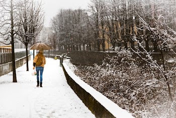Woman With Umbrella Walking on Snow Covered Sidewalk