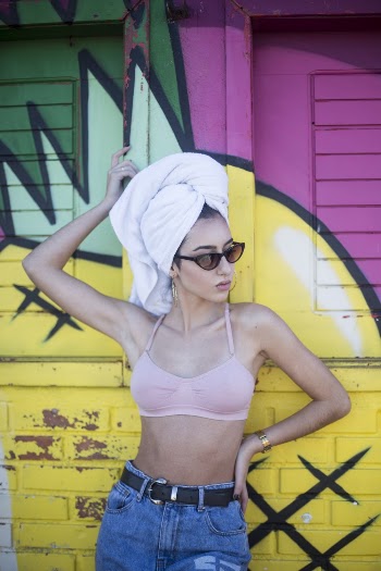 Woman With White Towel On Hair Standing and Leaning on Pink and Yellow Painted Wall