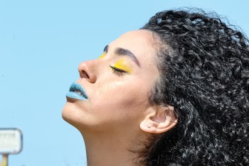 Woman With Yellow Eye Shadow and Blue Lipsticks With Eyes Closed Chin Up
